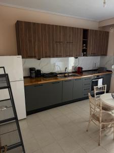a kitchen with wooden cabinets and a table and a chair at Το Σπίτι στον Πεζόδρομο in Grevena
