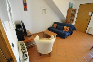 a living room with a couch and a chair at ApartmentsGarda - Baia D'Argento Residence in Costermano