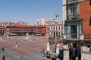 a city square with buildings and umbrellas and people at Edificio Ferrari 4, by Plaza Mayor Apartamentos in Valladolid