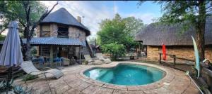 a swimming pool in front of a house at Elephant Memories wildlife lodge in Marloth Park