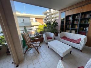 a balcony with two chairs and a couch and a table at B&B Imagine in Bari