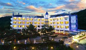 a large white building with lights in front of it at Benikea Swiss Rosen Hotel in Gyeongju