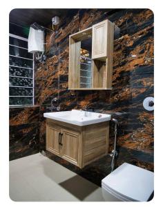 a bathroom with a sink and a toilet at Dheer- BnB at an Artist's Abode in Shānti Niketan
