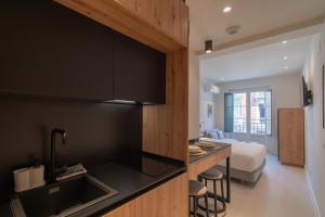 a kitchen with a sink and a bed in a room at Edificio Ferrari 4, by Plaza Mayor Apartamentos in Valladolid