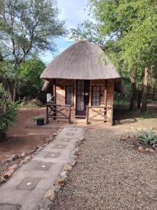 a small hut with a thatched roof and a pathway at Elephant Memories wildlife lodge in Marloth Park +43 photos