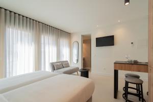 a bedroom with a bed and a desk and a chair at Edificio Ferrari 4, by Plaza Mayor Apartamentos in Valladolid