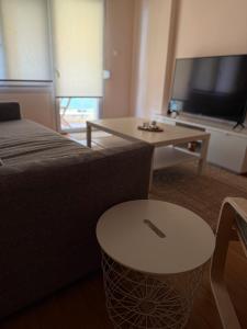 a living room with a couch and a table at Το Σπίτι στον Πεζόδρομο in Grevena