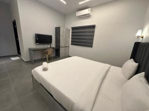 a bedroom with a white bed and a television at Hotel Siri Inn Hitech City in Hyderabad