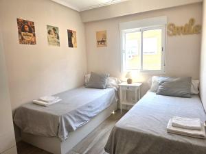 a bedroom with two beds and a window at PASARELA ALMOZARA HOME & Parking gratis in Zaragoza