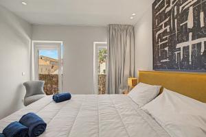 a bedroom with a large white bed and a window at Trafaria Bliss in Trafaria