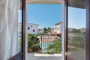 eine offene Tür zu einem Balkon mit Blick auf einen Pool in der Unterkunft Nurache in Orosei