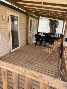 a wooden deck with a table and chairs on it at Chez Axel in Pradons
