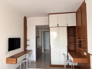 a living room with a tv and a desk with a television at FryB in Phnom Penh