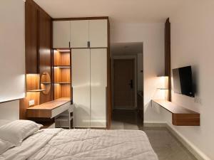 a bedroom with a bed and a mirror and a tv at FryB in Phnom Penh +4 photos