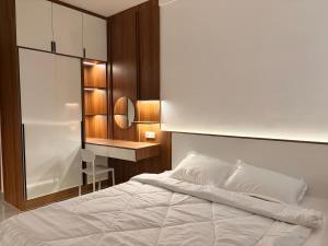 a bedroom with a white bed and a desk at FryB in Phnom Penh