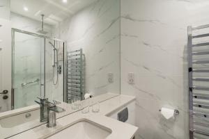 a white bathroom with a sink and a mirror at Skiddaw Hotel in Keswick +77 photos