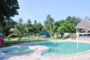 a pool at a resort with a person standing next to it at Gabsgate Resort Kilifi in Kilifi