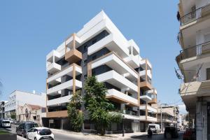 a tall white building on a city street at The Edge Piraeus Luxury Residences in Piraeus