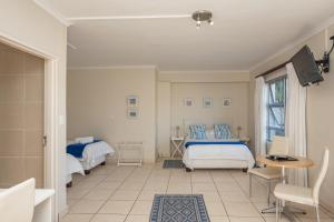 a bedroom with two beds and a television in it at Millard Crescent Guest House in Port Elizabeth +68 photos