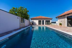 a swimming pool in front of a house at Kuća za odmor Leona in Dušić