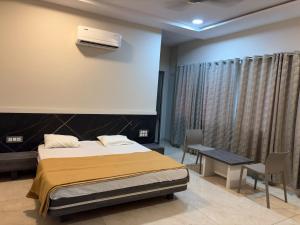 a bedroom with a bed and a air conditioner at Hotel VITHAI PALACE in Mehekar +7 photos
