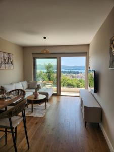 a living room with a couch and a large window at Apartman Bloom 6 in Tivat