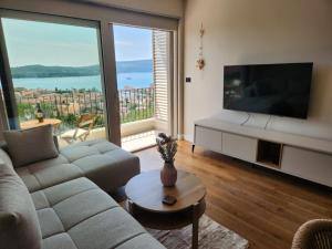 a living room with a couch and a flat screen tv at Apartman Bloom 6 in Tivat