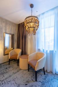 a living room with two chairs and a chandelier at Alpin Resort Hotel in Poiana Brasov