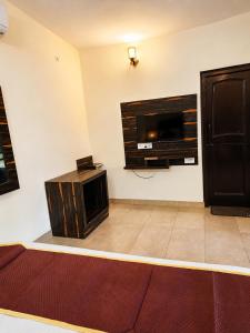 a room with a flat screen tv on a wall at Wildline Gold Resort in Dhikuli