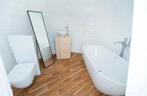 a bathroom with a tub and a toilet and a sink at Burbuja El Sueño del Duque in Villanueva de Tapia