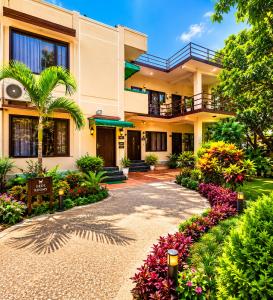a house with a garden and flowers in front of it at Wildline Gold Resort in Dhikuli