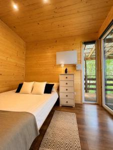 a bedroom with a bed in a wooden wall at Sarzynówka pod Sosną in Krasnobród