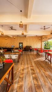 a dining room with wooden floors and tables at Wildline Gold Resort in Dhikuli