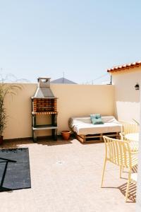 a patio with a bed and a grill at Alto Ferrel Guesthouse in Ferrel