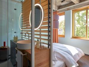 a bathroom with a sink and a mirror at 25hours Hotel The Circle in Cologne