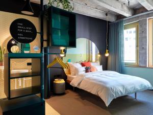 a bedroom with a bed and a tv on the wall at 25hours Hotel The Circle in Cologne +57 photos