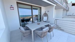 a white table and chairs with a view of the ocean at Son Serra Sea Coast Villa in Son Serra de Marina
