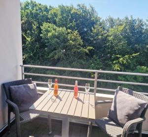 a table with two bottles and glasses on a balcony at Apartment Sonnendeck in Ulstrupfeld