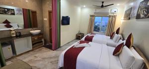 a hotel room with two beds and a bathroom at Hotel KSR Grand in Srikalahasti +14 photos