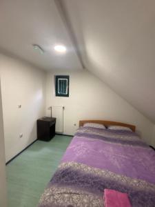 a bedroom with a purple bed in a attic at Staro Lane in Sjenica