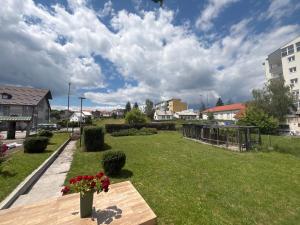 a park with a bench and flowers on a field at Staro Lane in Sjenica