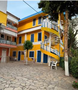 a yellow and blue building with a staircase at Gregor Villa in Asim Zeneli