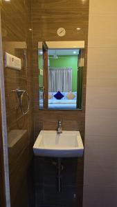 a bathroom with a sink and a mirror at Hotel KSR Grand in Srikalahasti
