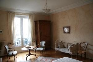 ルマンにあるChambres d'hôtes Le Clos d'Hautevilleのベッドルーム1室(ベッド1台、テーブル、椅子付)