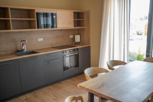 a kitchen with gray cabinets and a wooden table at Amenity Usedlost v Marinkách in Blažejov