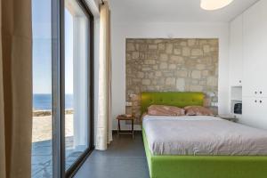 a bedroom with a bed with a stone wall at Villa Belo in Kastrí