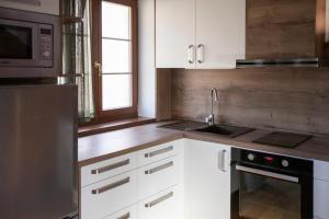 a kitchen with white cabinets and a sink and a microwave at Amenity Usedlost v Marinkách in Blažejov +37 photos