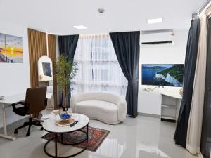 a living room with a chair and a table at Dee Residence Phuket in Patong Beach