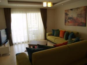 sala de estar con sofá y TV en Orion Resort Elif 17, en Avsallar