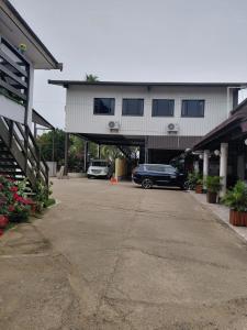 a parking lot with cars parked in front of a building at Standard - Bluelight Village Hotel in Nadi